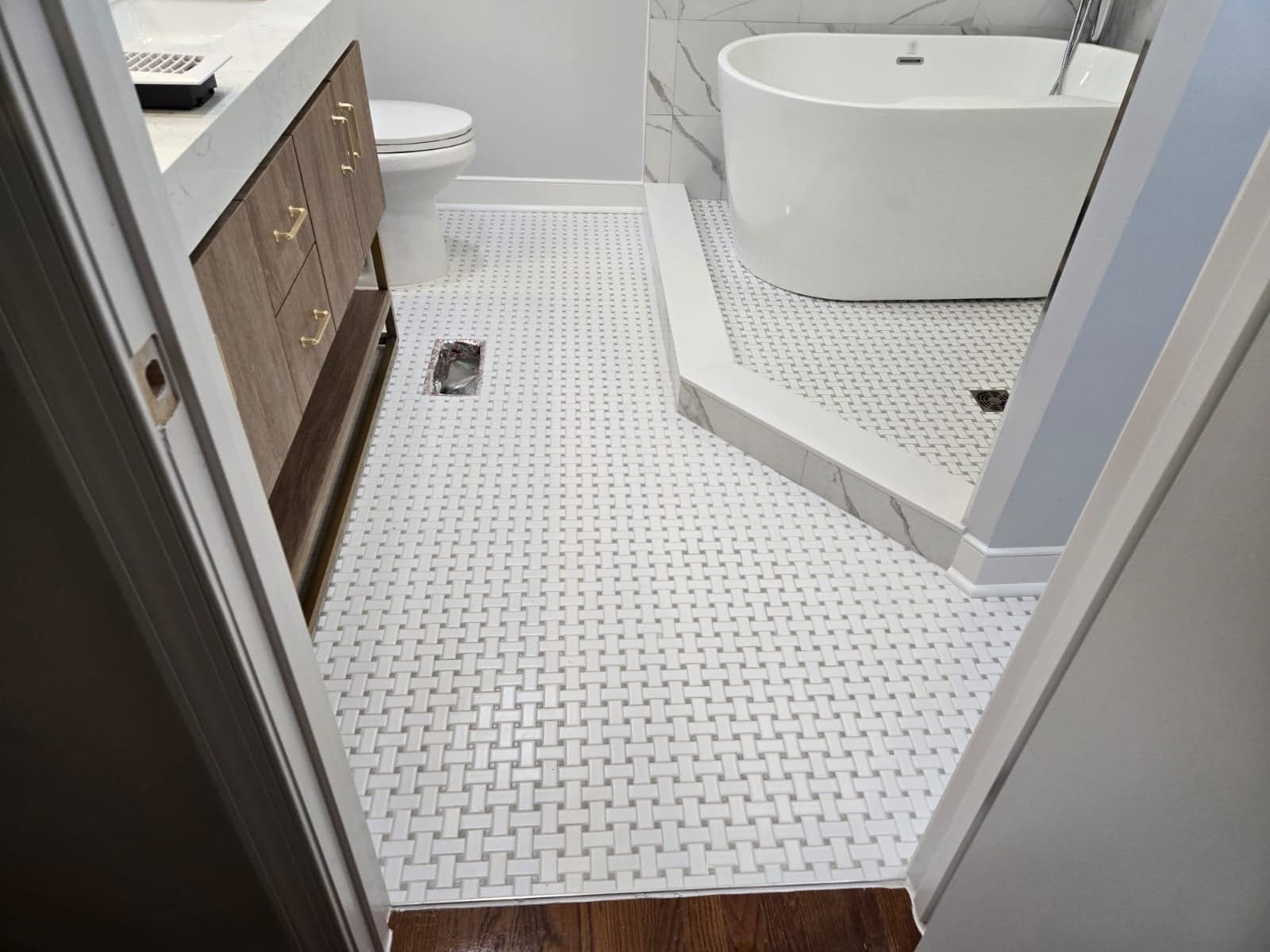 White basketweave mosaic tile bathroom floor installed by MAS Contractors in Richmond, VA — freestanding tub surround