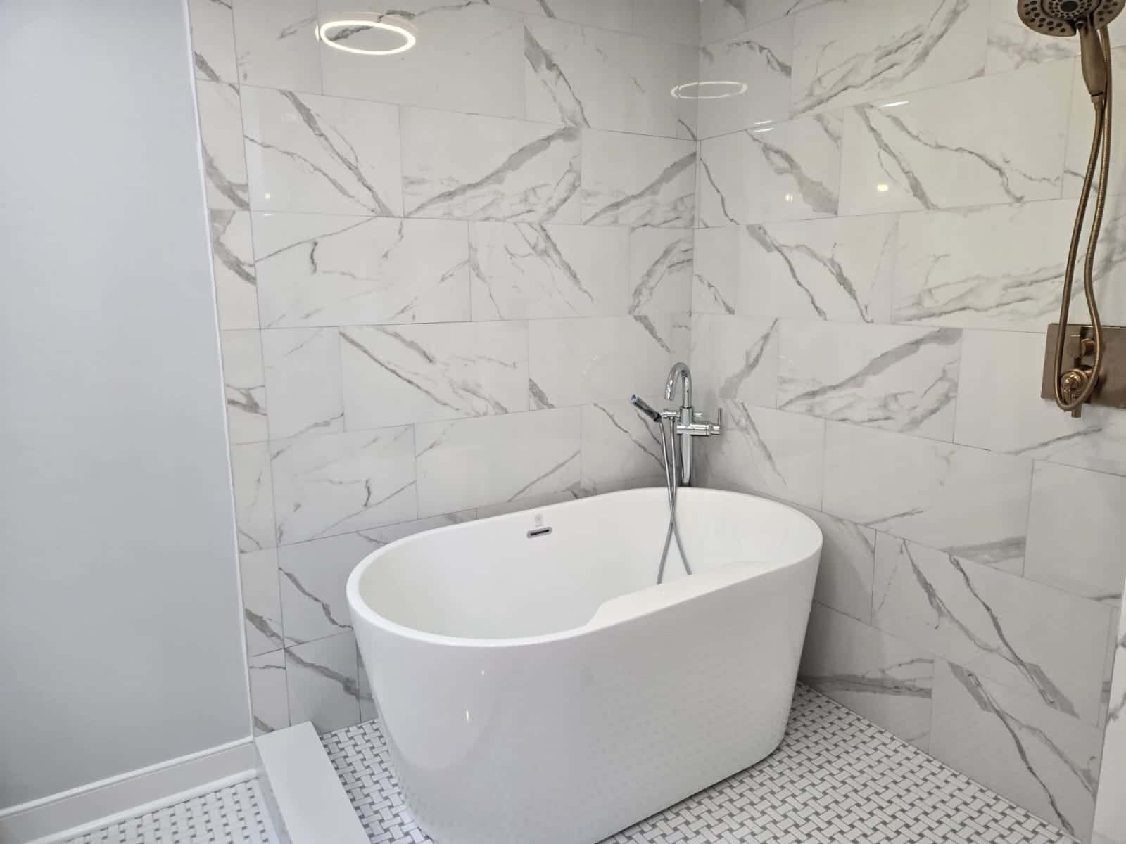 Bathroom remodel in Richmond, VA by MAS Contractors — freestanding tub with large-format marble-veined tile and basketweave mosaic floor